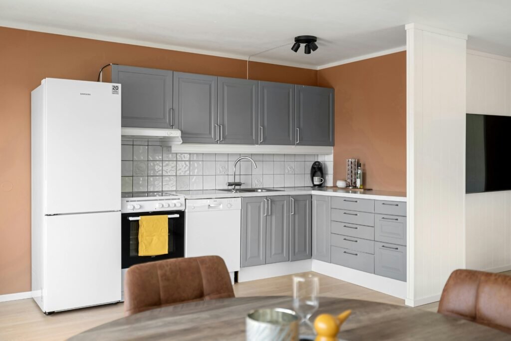 Contemporary kitchen with gray cabinets and modern appliances in a minimalist setting.